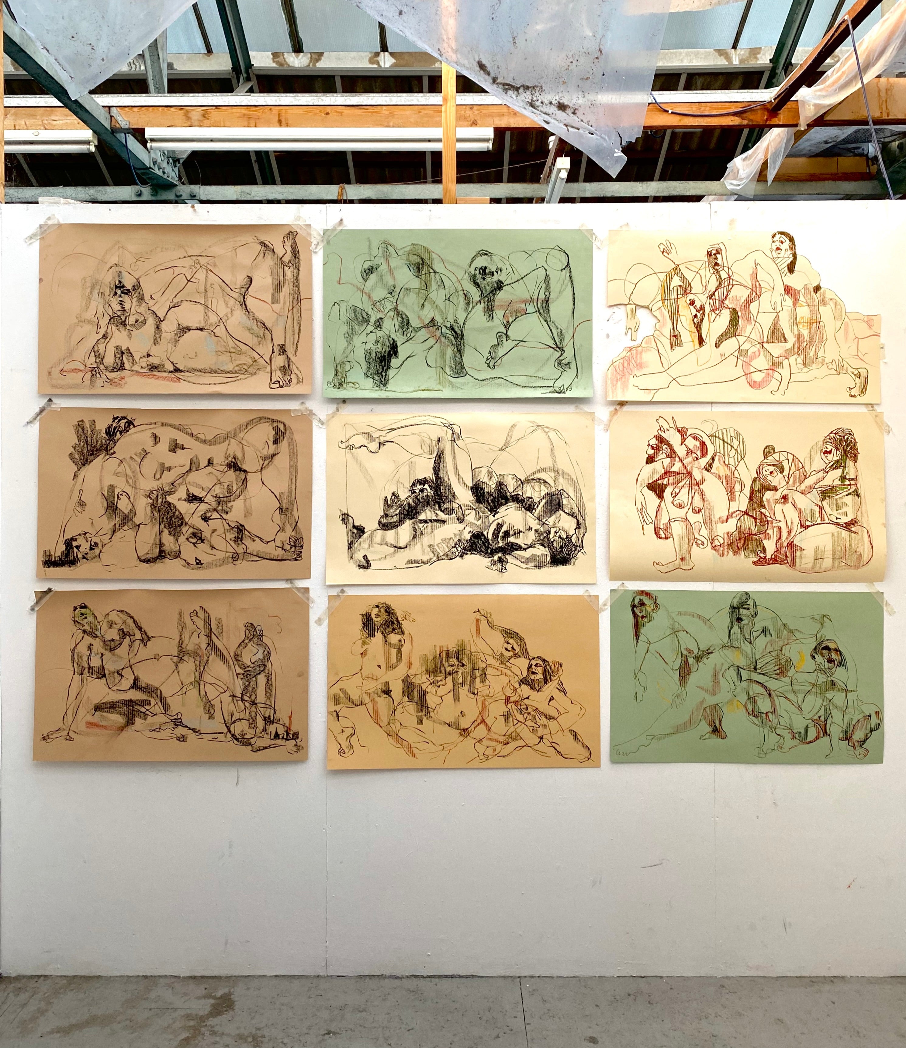 Set of nine framed artworks on a wall with a modern indoor setting.
